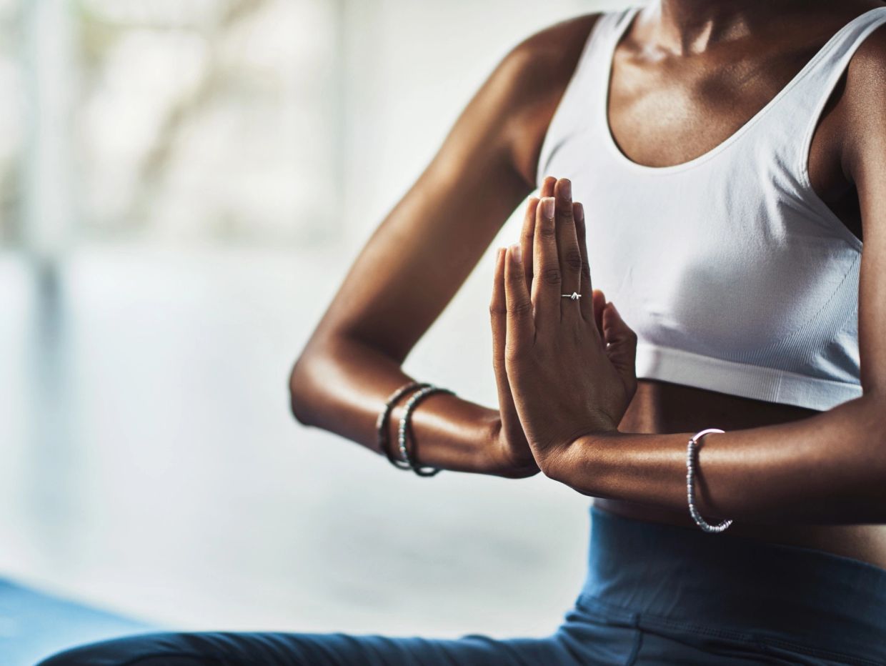 Person meditating with hands in prayer pose.