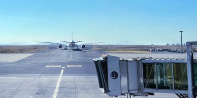 Jet bridge and airplane on the runway at an airport.