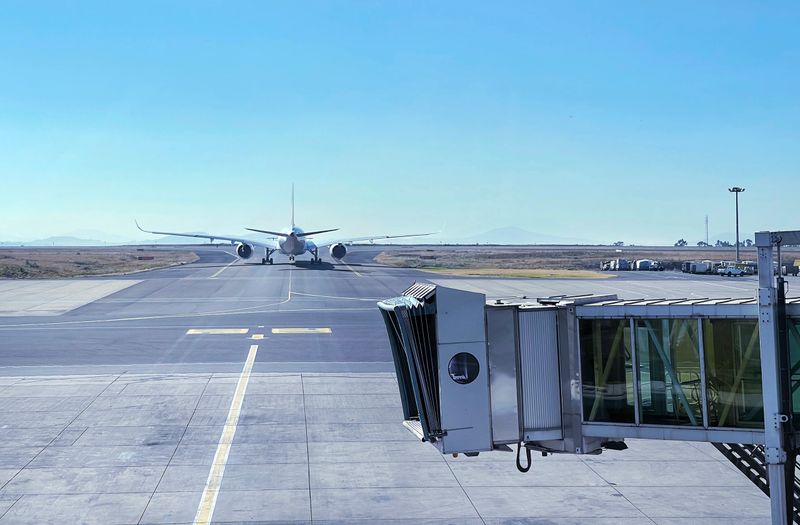 Jet bridge with Aircraft driving by the runway before airplane takeoff. Airways and transportation concept image at Addis Ababa airport, Ethiopia.