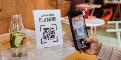 Person scanning a QR code to access a menu at a restaurant.