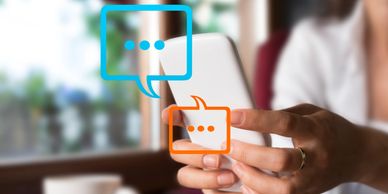 Person using smartphone with chat bubbles indicating messaging.