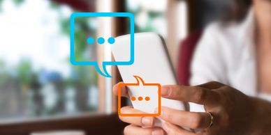 Person using smartphone with chat bubbles indicating messaging.