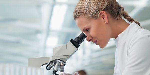 Scientist examining through a microscope.