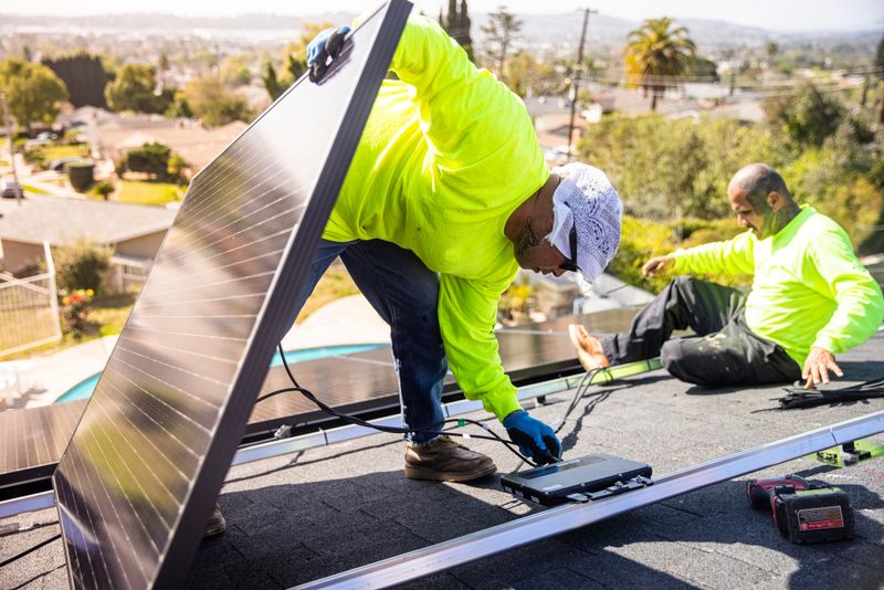 A team of workers installing solar panels on a home in Southern California