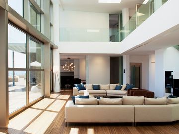 Helles, modernes Wohnzimmer mit großen Fenstern und Sofas.