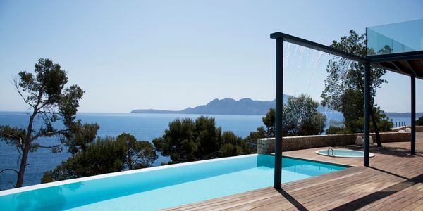 Piscina infinita con vista al mar y montaña.