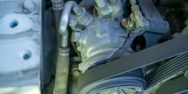 Close-up of a car engine belt and pulley system.