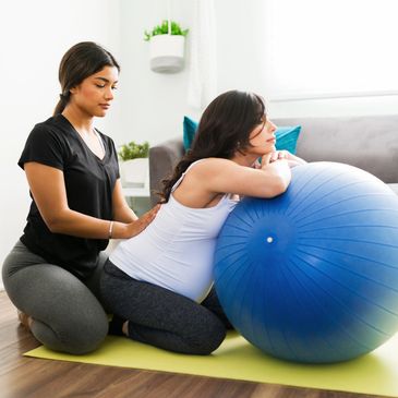 A woman receiving physical therapy with an exercise ball.
