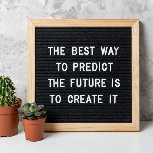 Inspirational message on a letter board with potted succulents beside it.