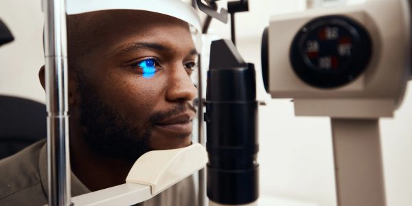 Man undergoing eye examination with blue light.