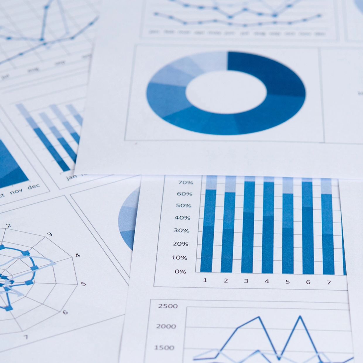 Various blue-toned charts and graphs on paper beside a keyboard.