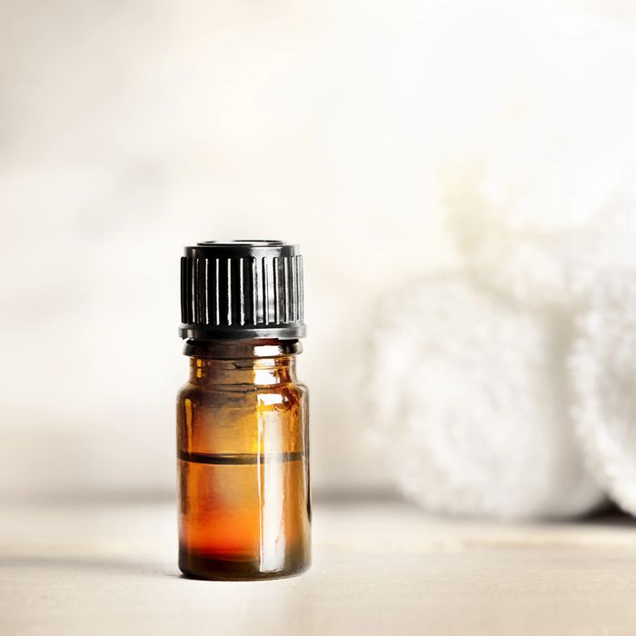 Small amber glass bottle with black cap, likely essential oil or serum.