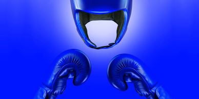 Blue boxing gloves and headgear against a blue background.