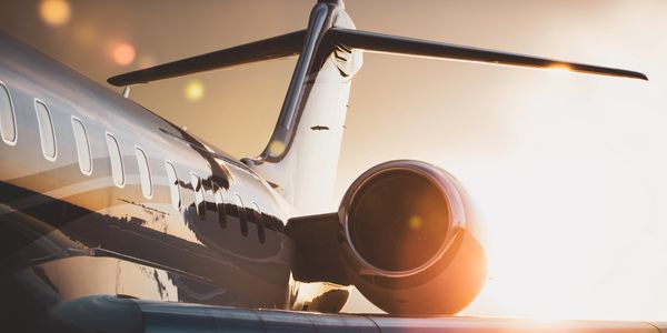 Close-up of a private jet engine at sunset with warm reflections.