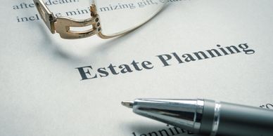 A pen and glasses on a document titled Estate Planning.