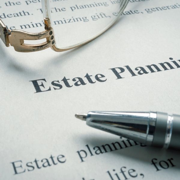 Close-up of estate planning document with pen and glasses.