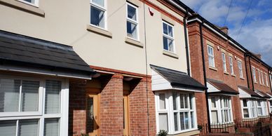 Row of modern brick townhouses with wooden doors and white-framed windows. Duplex or condo insurance 