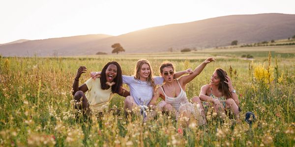  women sitting in a field of flowers