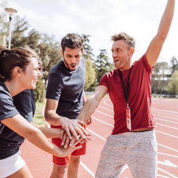 Team celebrating together on a running track.