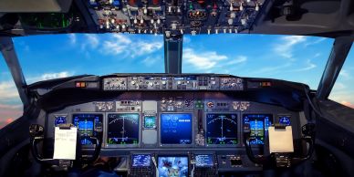 Inside view of a modern airplane cockpit with multiple displays.
