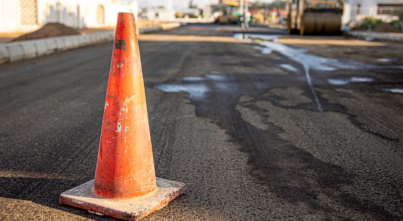 Close up of an orange traffic cone on the road copy space.
