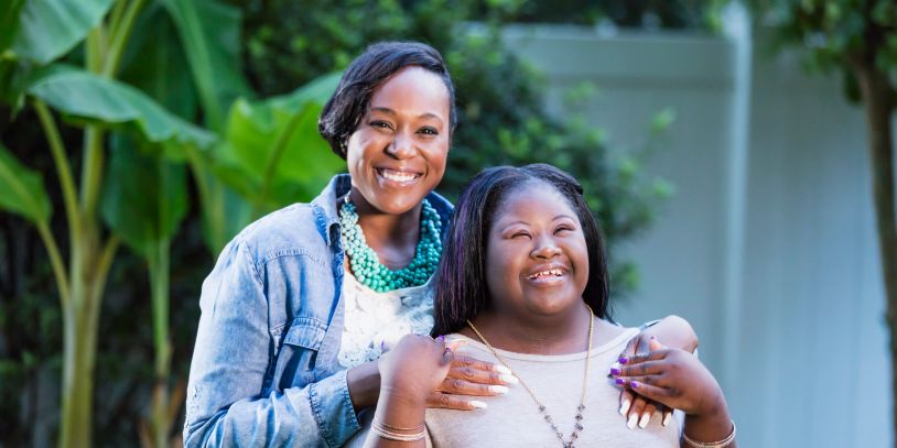 Two women smiling joyfully outdoors.