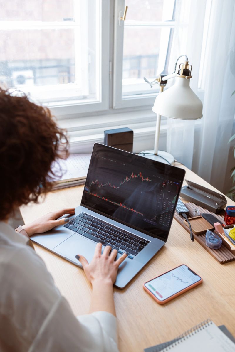 An unrecognizable female investor analyzing a company's financial report in her home office.