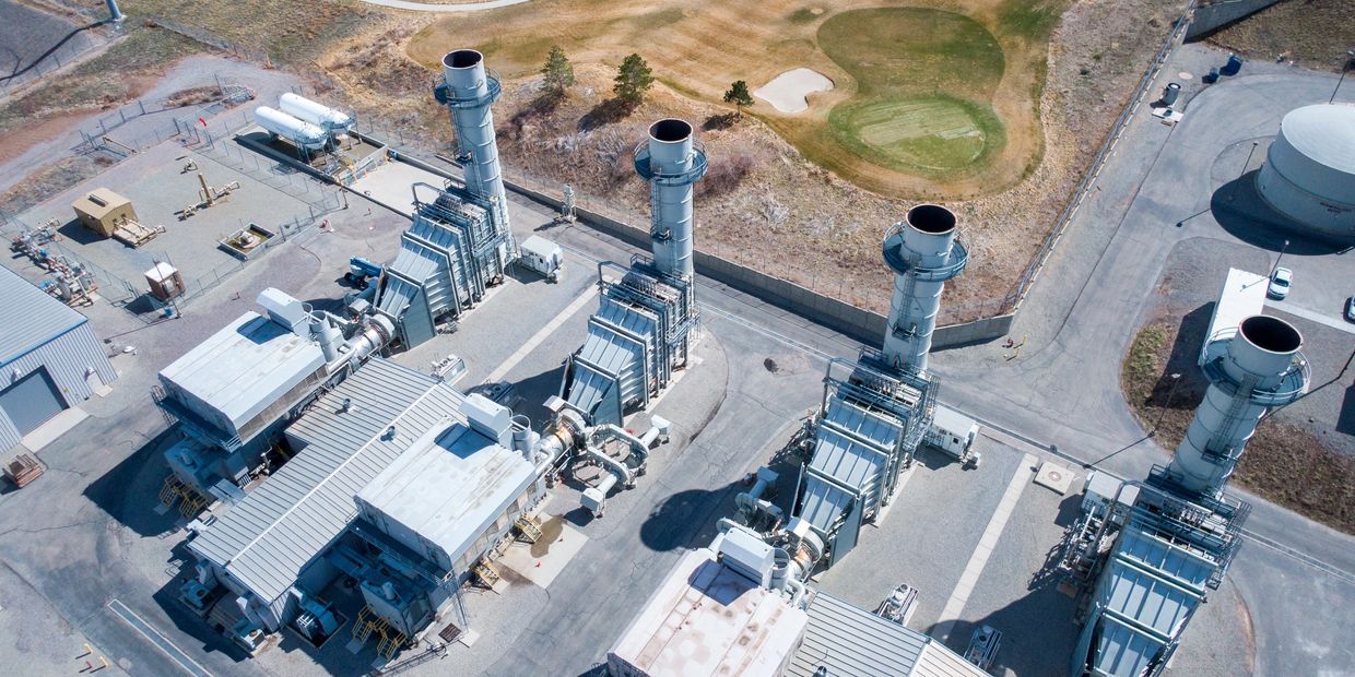 Aerial view of an industrial power plant with large chimneys and machinery.