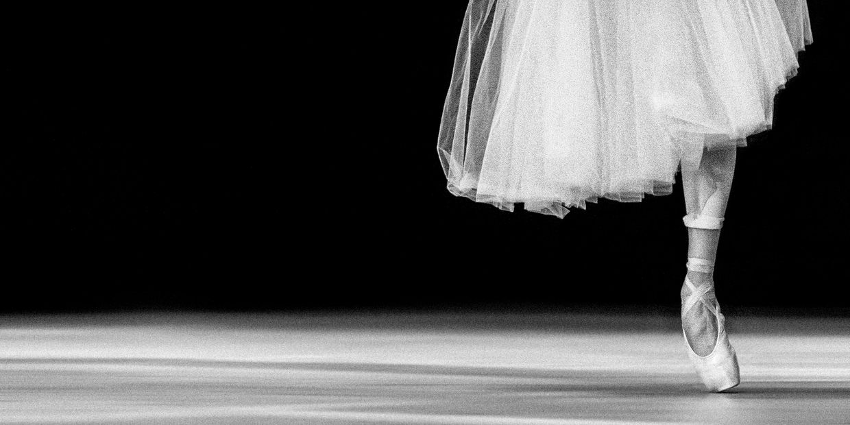 Ballerina standing on pointe in a white tutu.