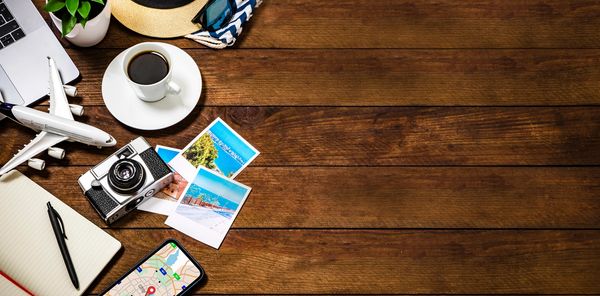Passport, sunglasses, and travel essentials on a wooden surface.