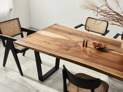 Wooden dining table with wicker chairs in a minimalist room.