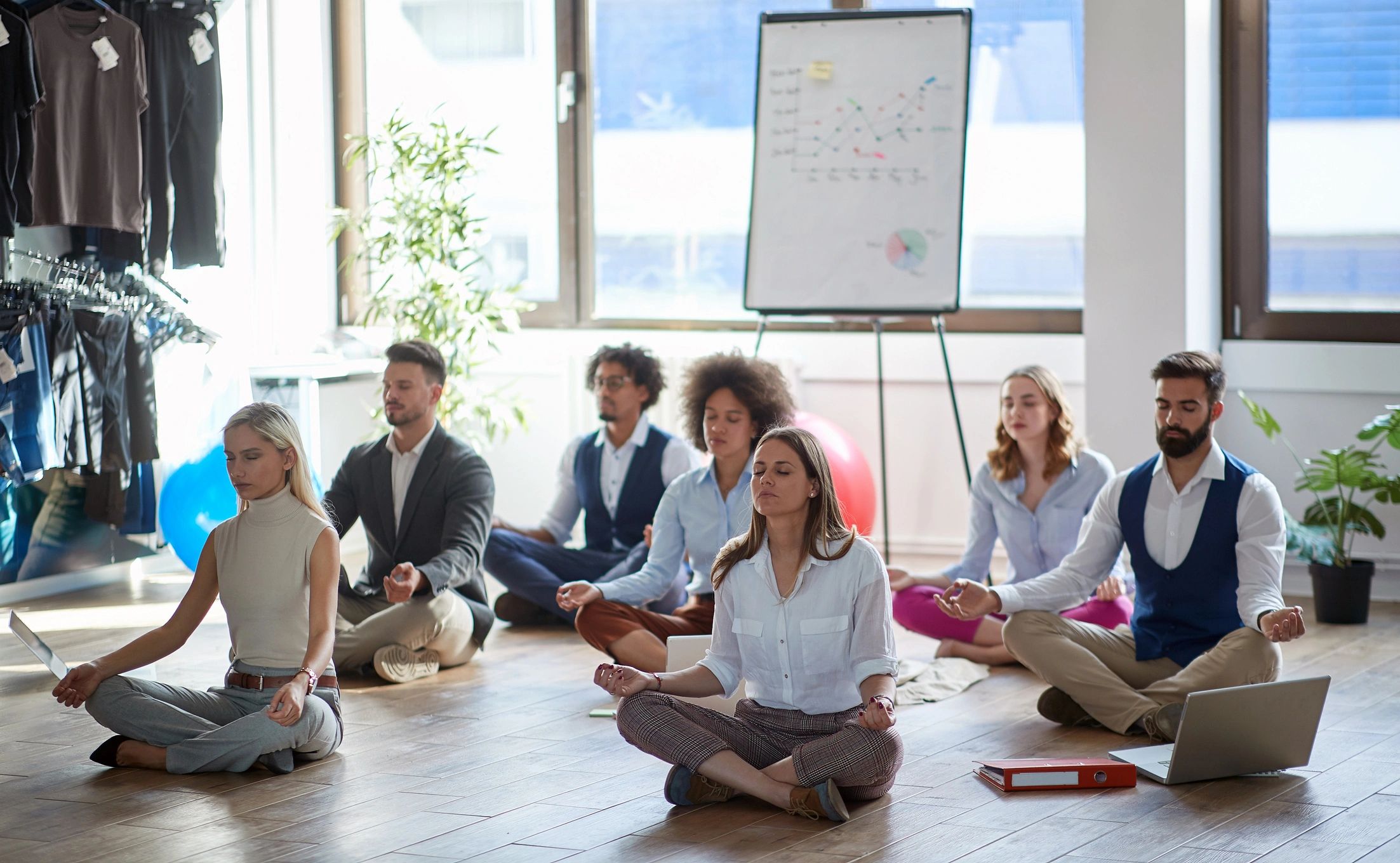 Diverse group of employees in a workplace group meditation workshop.
