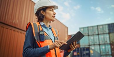 Female worker with tablet at shipping containers.
