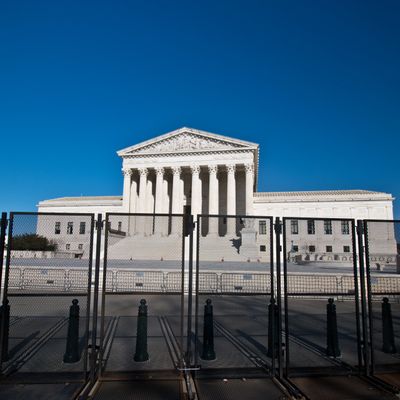 Supreme Court building behind security fences on a clear day.