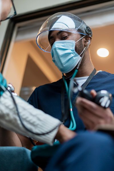 Médico comprobando la presión arterial de un paciente.