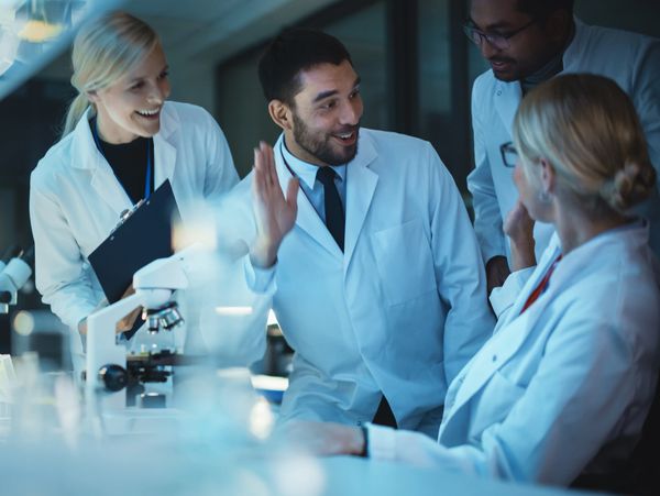 A group of lab scientist looking cheerful as though they have had a breakthrough