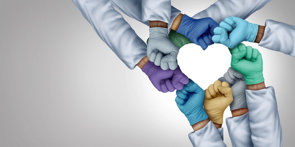 Healthcare professionals joining hands in partnership circle.