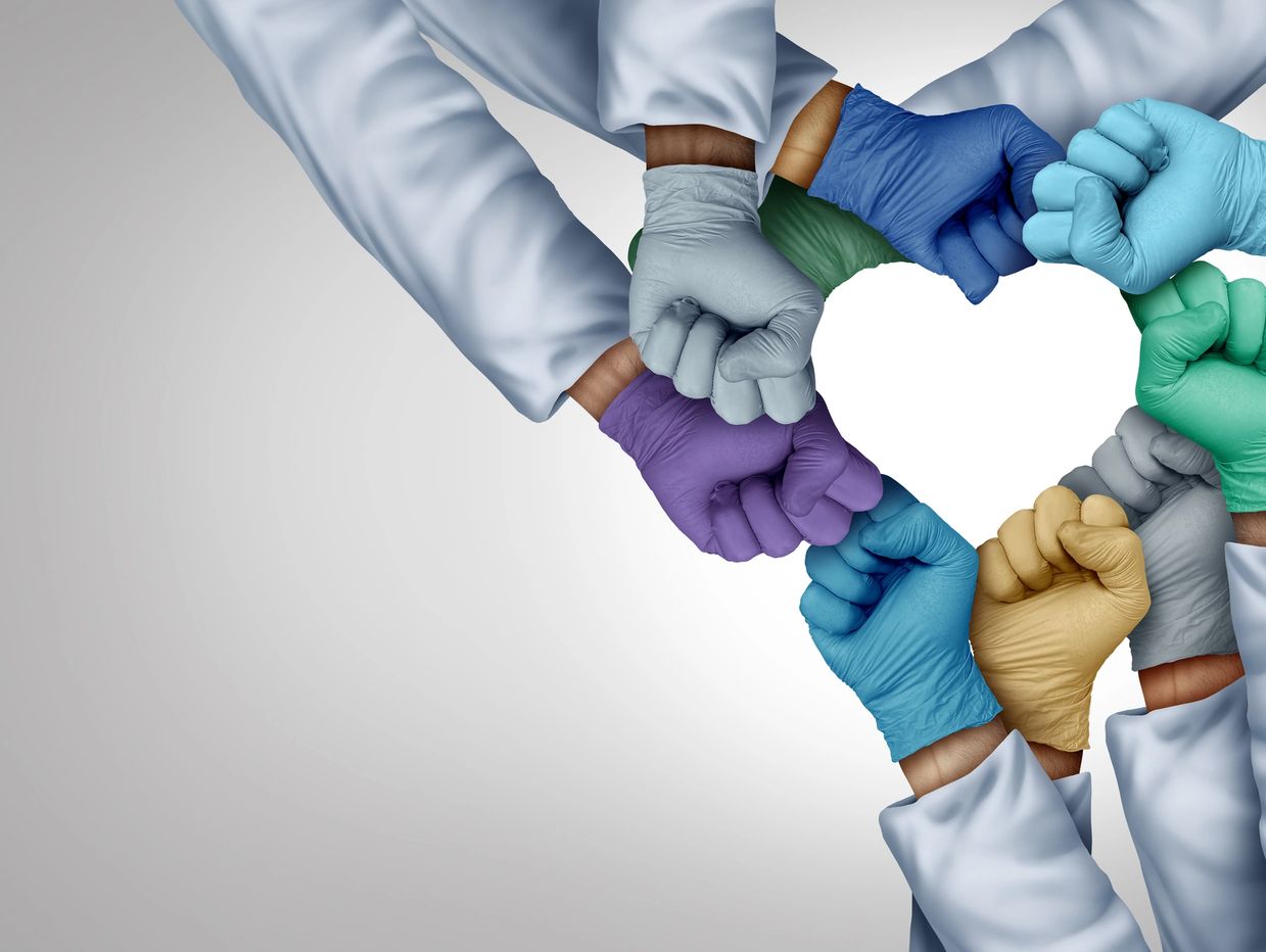 Doctors form a heart shape with gloved fists, symbolizing unity and care.