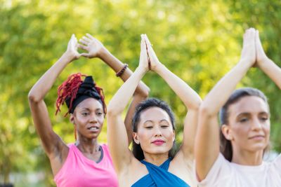 Women enjoying wellness yoga in the park.