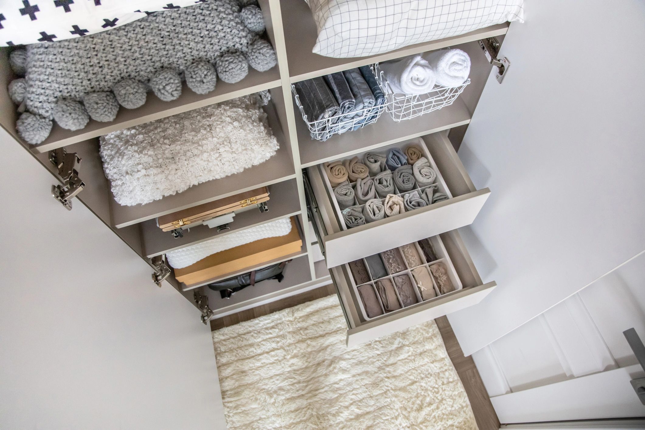 Neatly organized wardrobe with folded clothes and soft blankets.