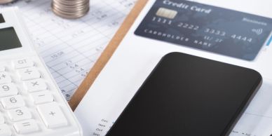 Smartphone, credit card, and calculator on financial documents.