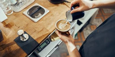 Barista pouring milk to create latte art.