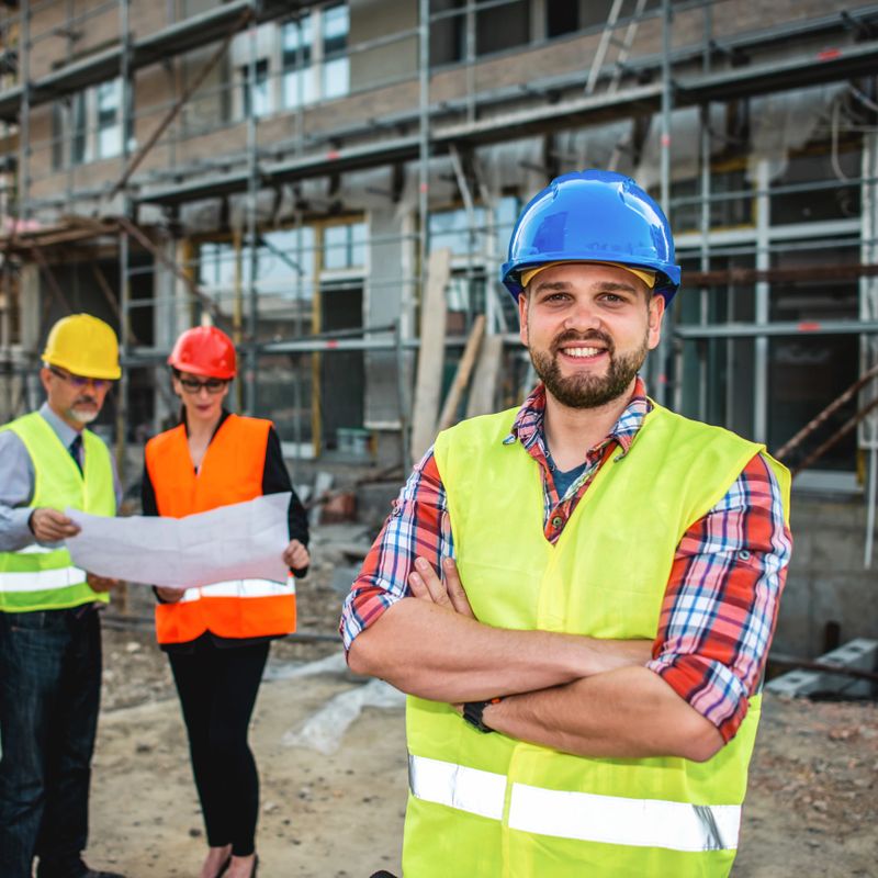 Group of smiling builders in hardhats outdoors