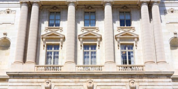 Facade of a neoclassical building with tall columns and ornate windows.