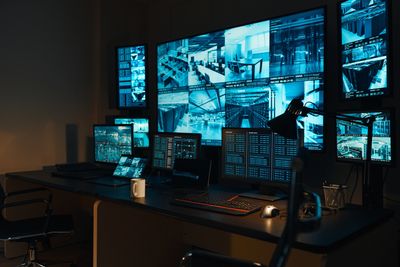 A high-tech surveillance room with multiple monitors displaying security footage.