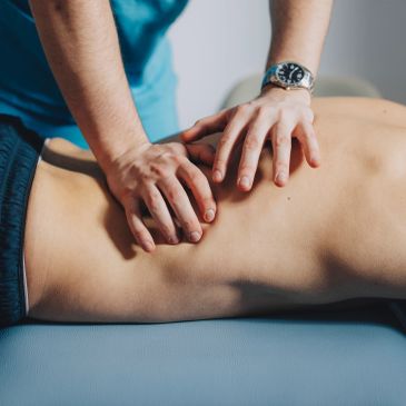 Hands giving a back massage.
