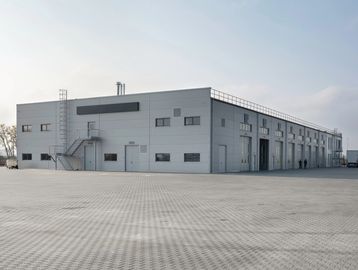 Large modern warehouse with multiple loading docks and a spacious paved area.
