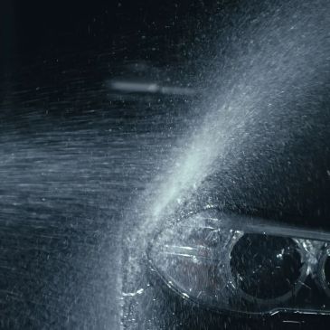 Water spraying on a car headlight.