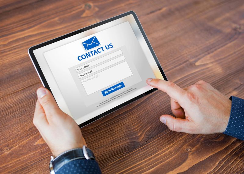 Man using tablet for submitting contact form on website