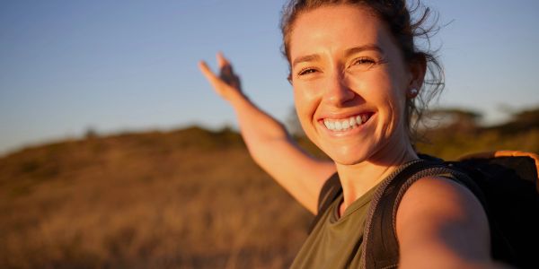Smiling woman hiking outdoors with backpack.
